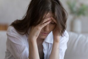 Woman With Hands on Forehead