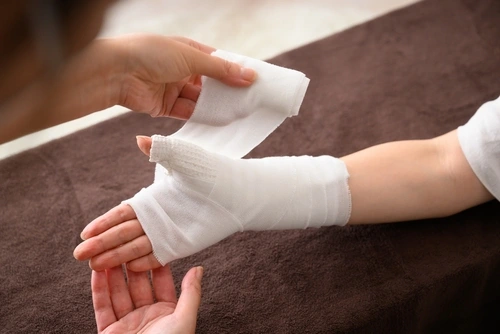 Hand and wrist being wrapped in gauze after a Fontainebleau work injury