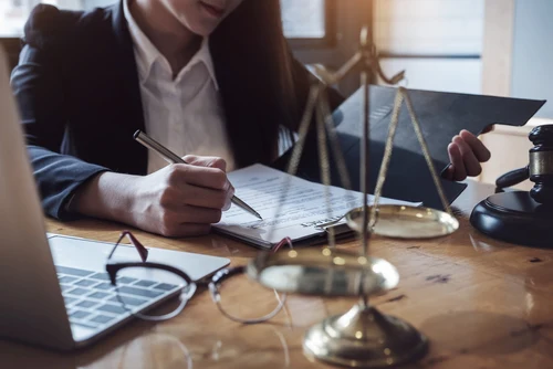 Lawyer doing paperwork at a desk with a scale on it